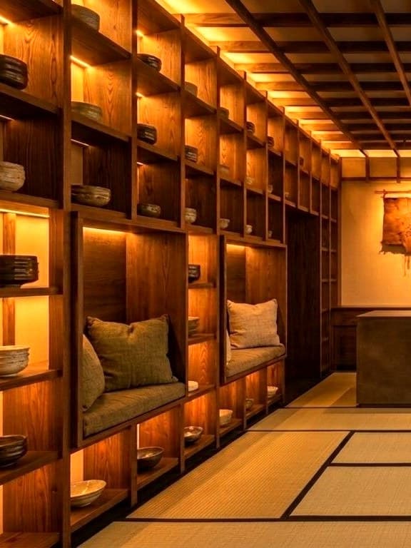Estanterías de madera iluminadas con cuencos de cerámica.